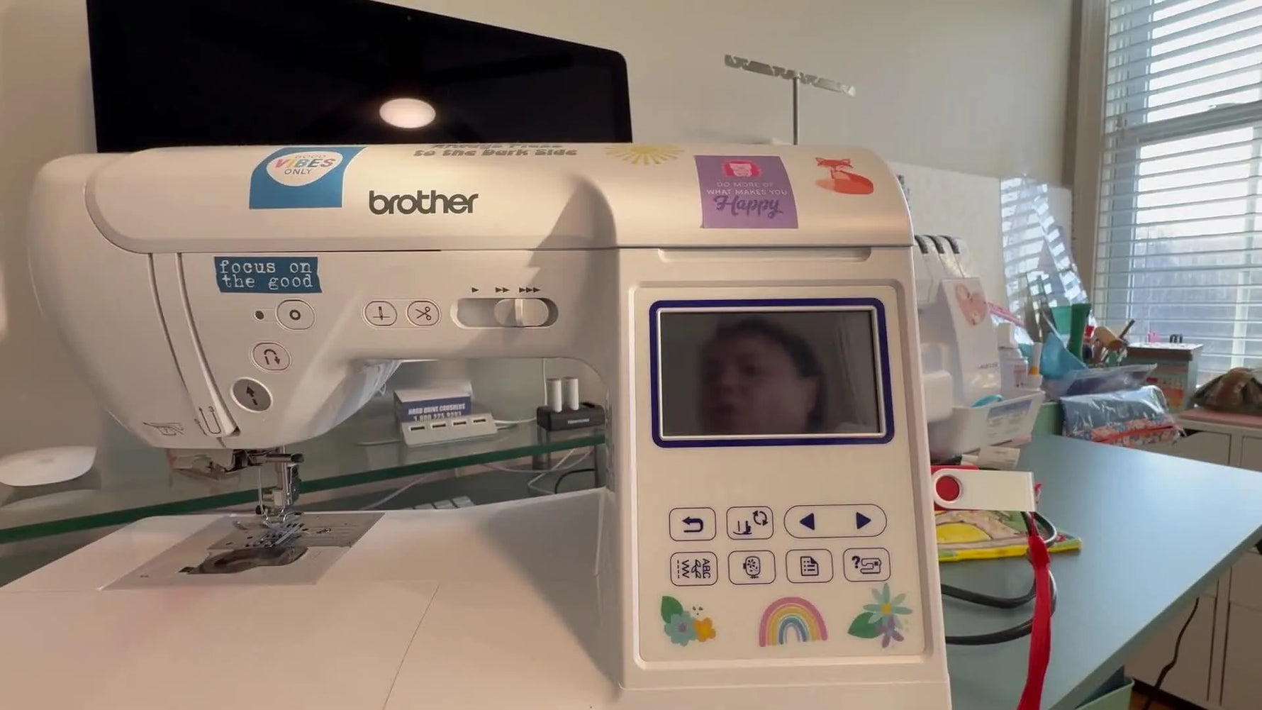 A close-up of a Brother SE1900 owner holding the Needle Position button while switching the machine on to enter firmware update mode.