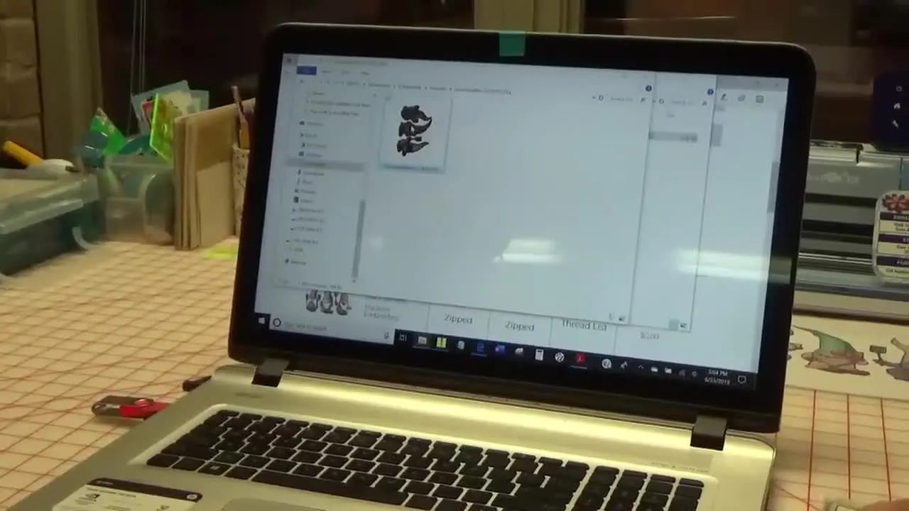 Embrilliance is open on a laptop with a hoop workspace ready for importing an embroidery design and printing a placement template.