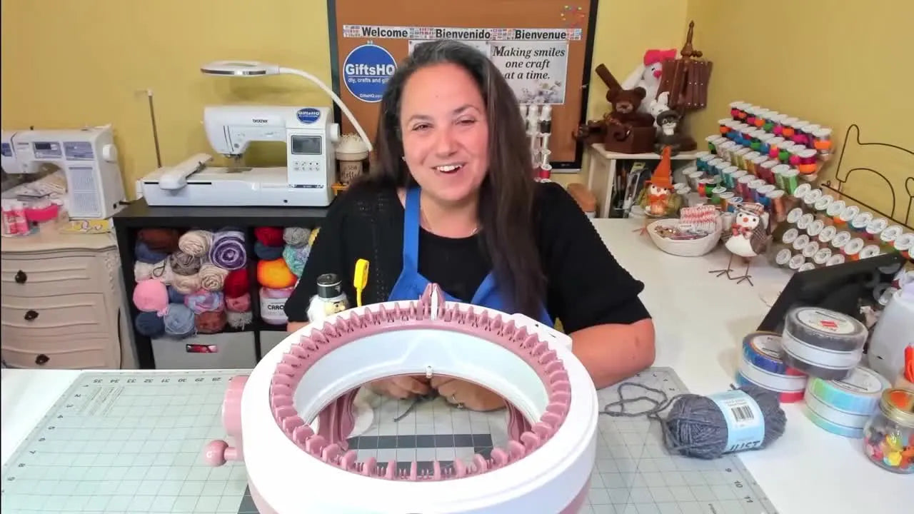 A woman smiling with a Sentro 48âpin knitting machine in front of her.