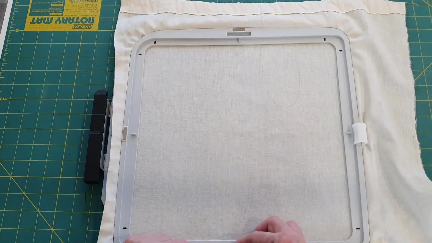 Overhead view of magnetic clips securing calico in a large embroidery hoop to stabilize a puffy Quilt-As-You-Go block.