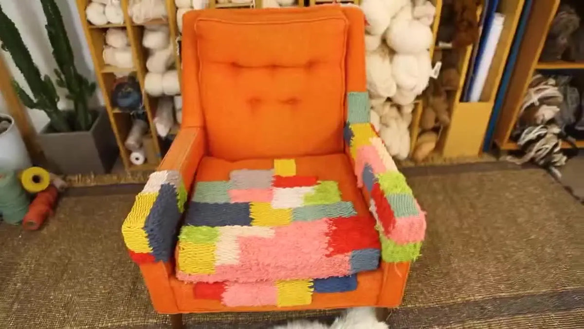 Fully repaired mid-century orange armchair with colorful woven patches.