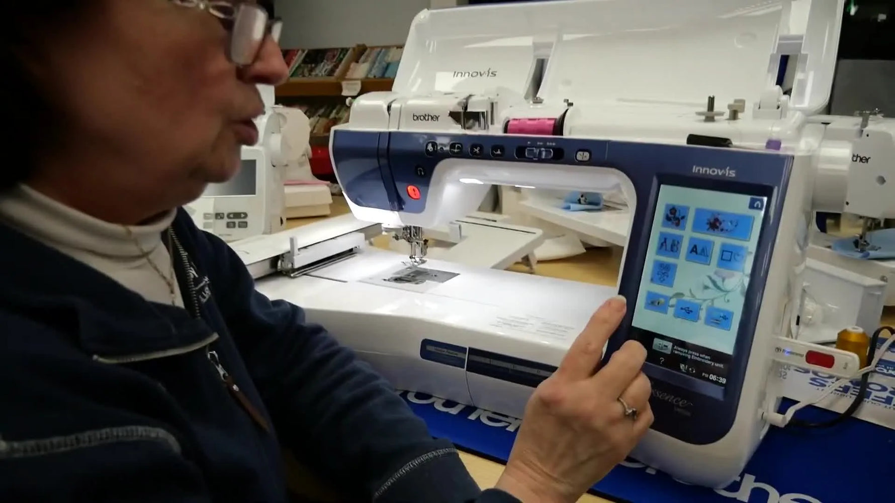 Close-up of the Brother Essence VM5200 touchscreen showing the home menu with the Embroidery option ready to select.