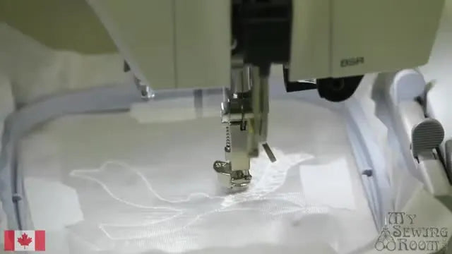 A close-up of the lace structure forming on transparent stabilizer inside the hoop during stitching.