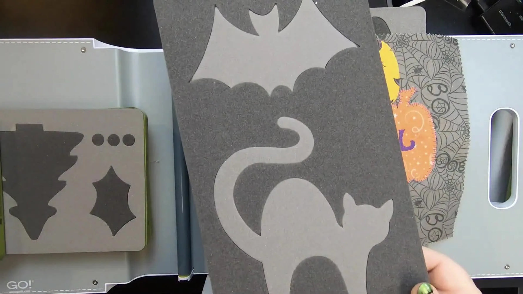 Close-up of the AccuQuilt Cat and Bat die board, highlighting the thin curved tail area that needs extra stabilization for clean appliqué stitching.