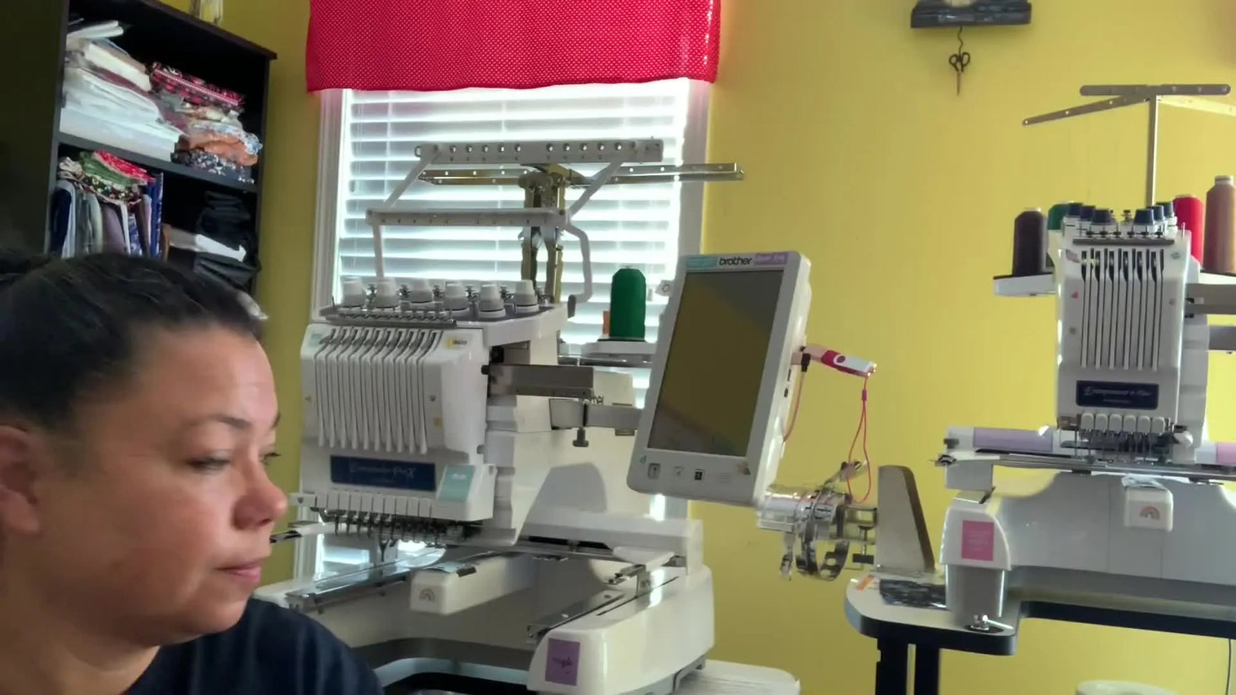 A wide shot showing the size and workflow difference between a compact single-needle flatbed setup and a larger multi-needle embroidery machine on a stand.