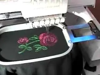 A close-up of the completed rose embroidery still hooped on the Baby Lock Endurance tubular arm, ready for the next mixed-media step.