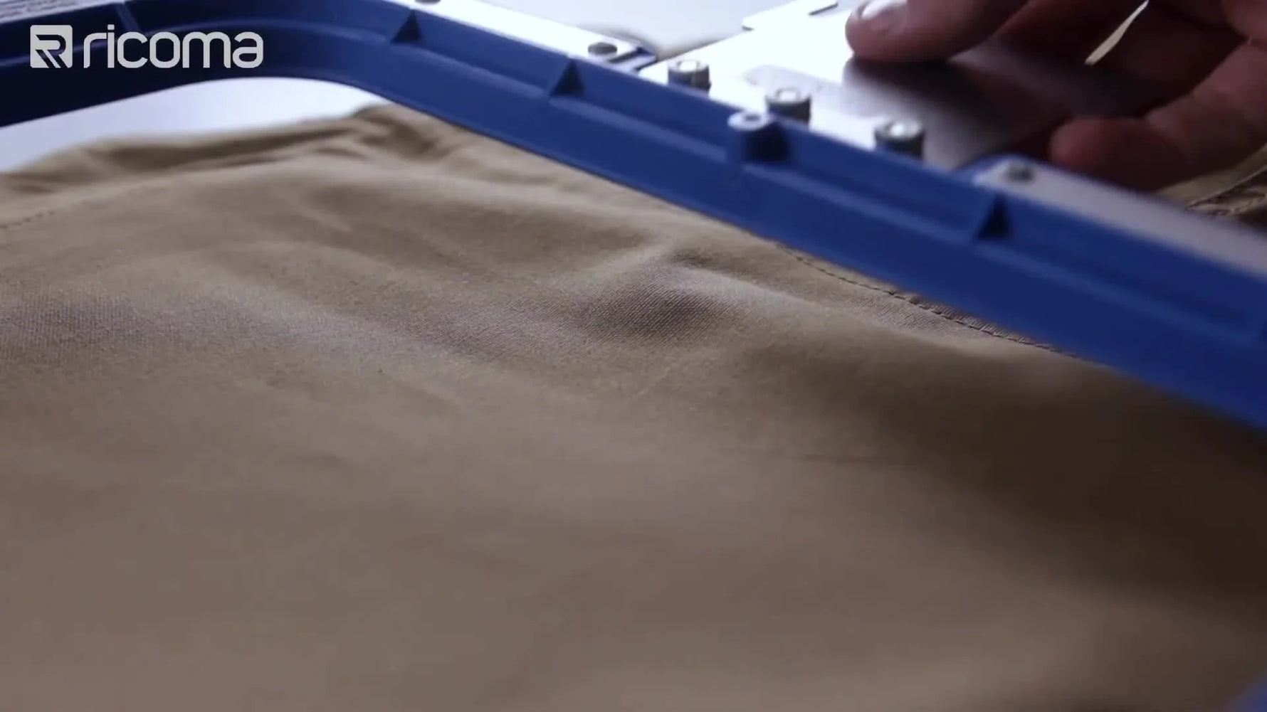 A close-up shows a blue magnetic hoop snapping onto a garment with the backing bracket visible, highlighting fast, repeatable hooping for production work.