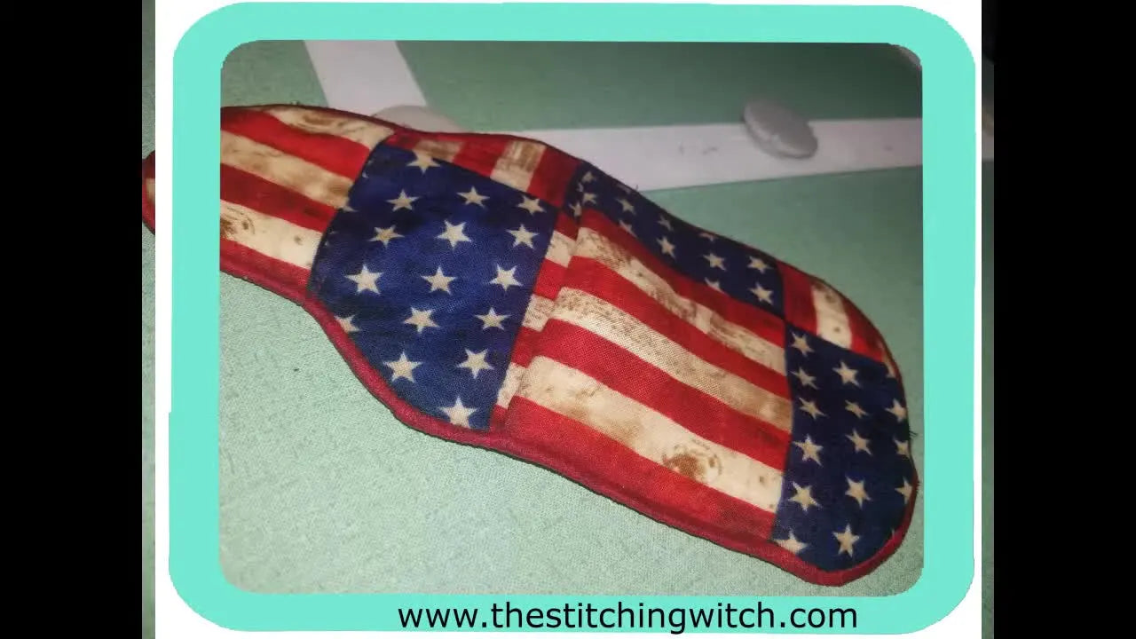 A finished finger-and-thumb ITH pot holder is shown on a hand, highlighting the pocket placement and final shape.
