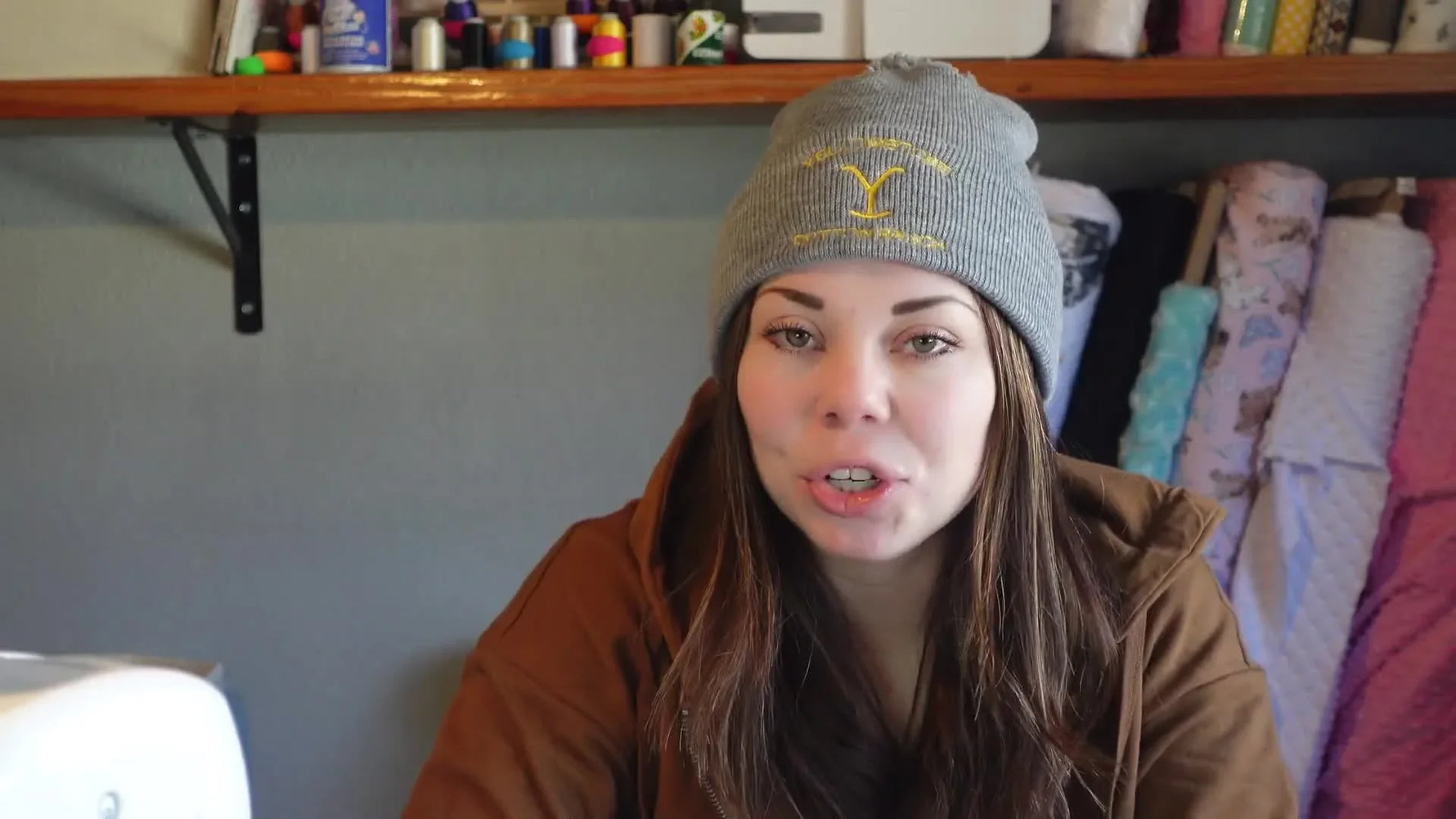 Woman wearing an embroidered Yellowstone beanie, smiling at the camera.