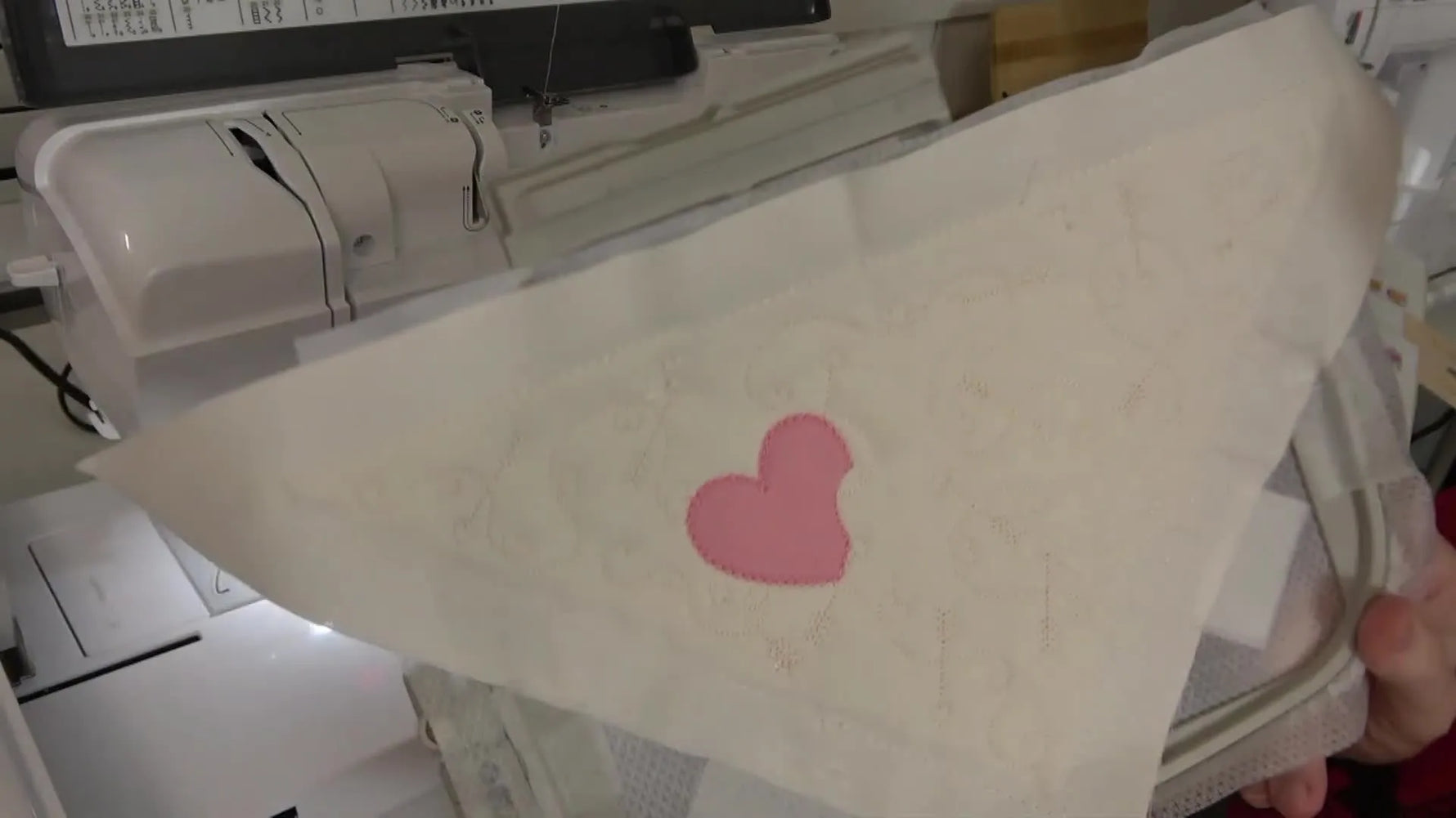 A macro close-up of a finished stitched heart shows crisp edges and clean coverage before the vinyl overlay makes mistakes permanent.