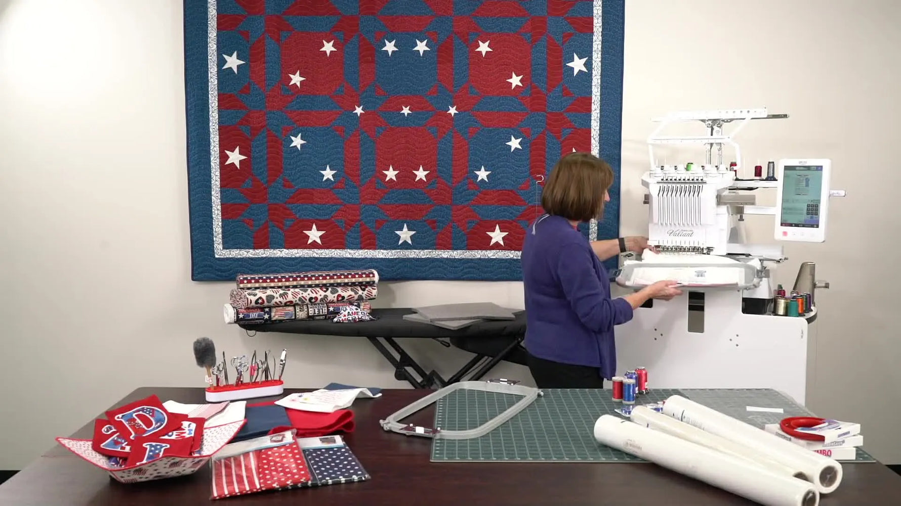 A side view of a hooped towel bunching behind a multi-needle embroidery machine, showing exactly why rotating the design prevents fabric from getting caught.