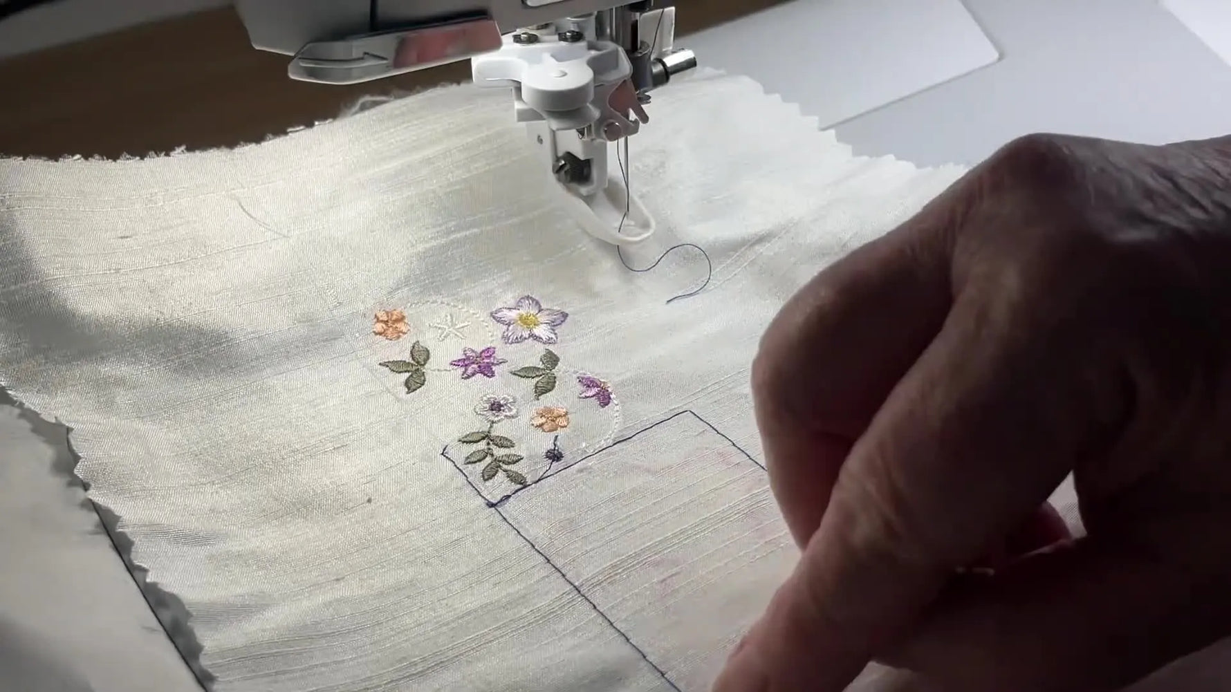 A close-up alignment check where the needle hovers precisely over the previous motif’s endpoint to guarantee a clean continuous join.