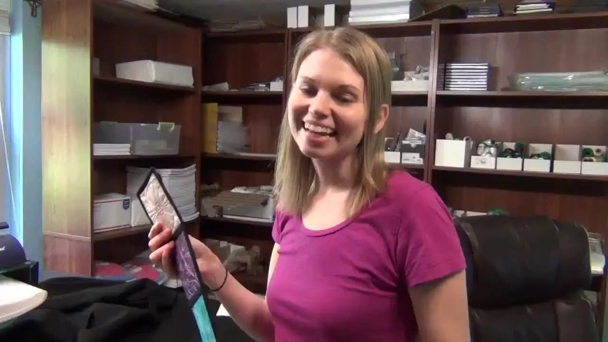 Woman holding a finished skinny chakra wall hanging.