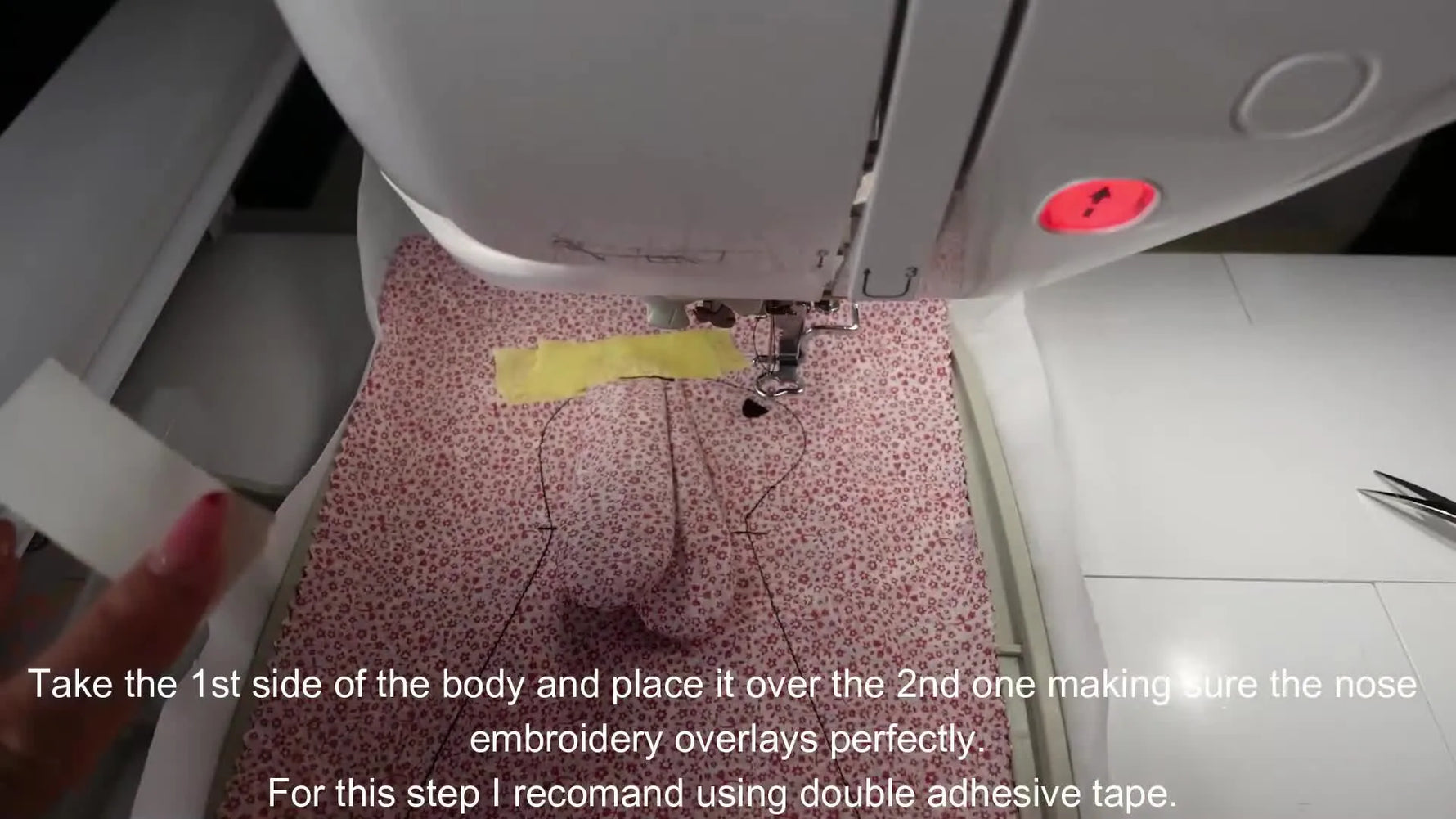 Aligning two body halves with double-adhesive tape for nose embroidery.