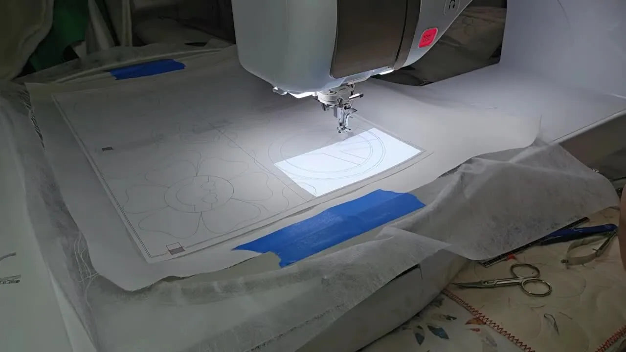 A Baby Lock Solaris running a large 10 5/8" x 16" hoop with white fabric loaded, ready for edge-to-edge quilting.