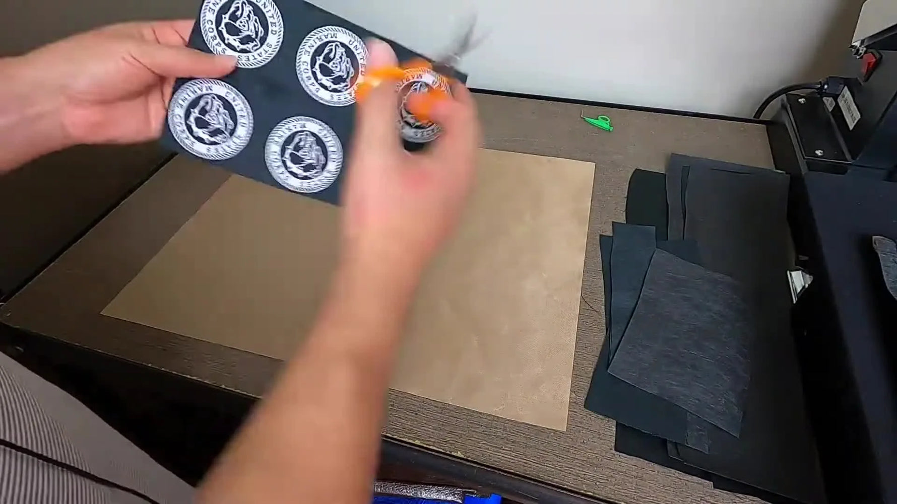 A close-up shows a hot knife cutting a circular embroidered patch, sealing the edge as it separates cleanly from the sheet.