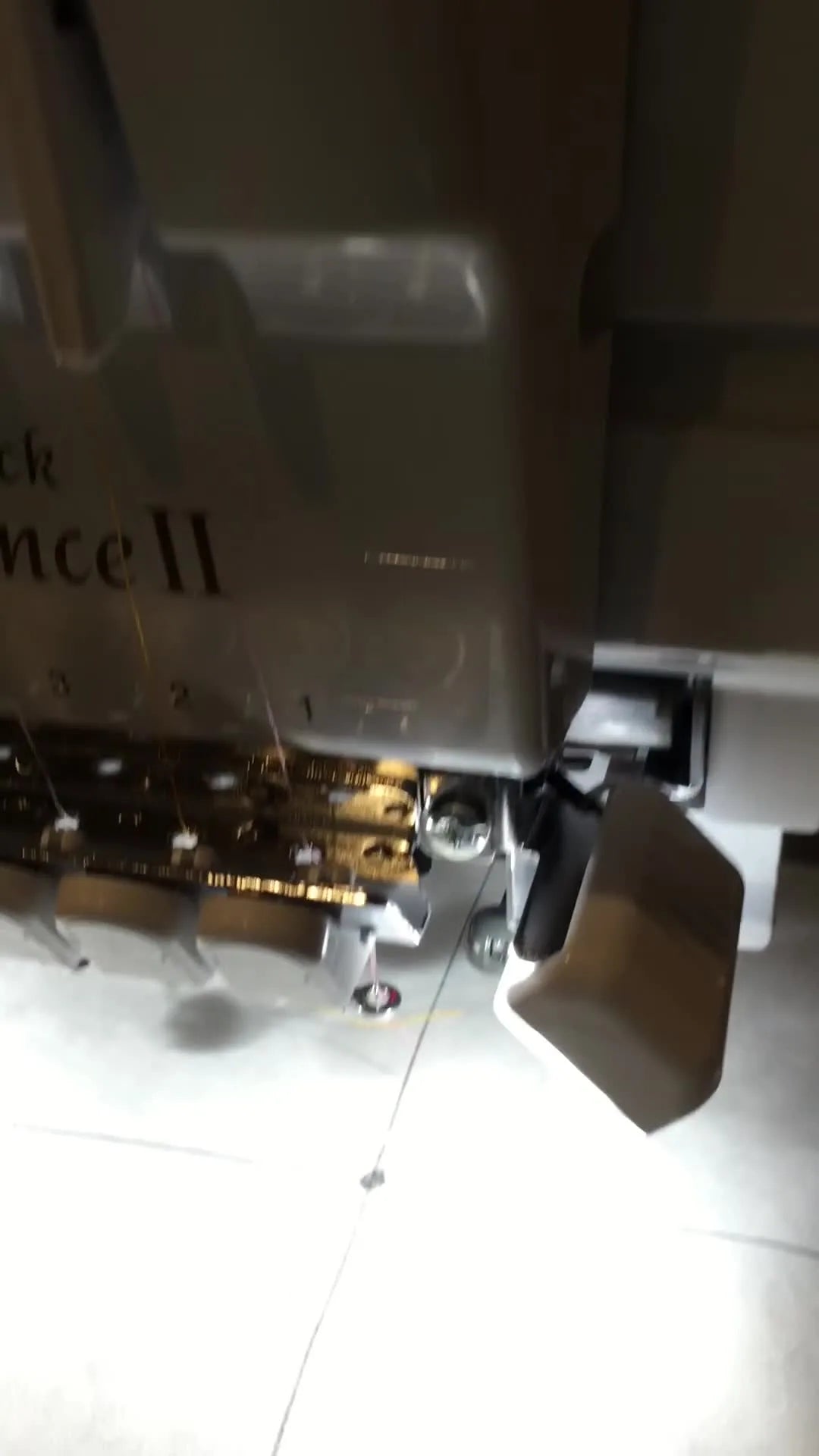 Close-up of the Baby Lock Endurance II red laser guide dot shining on stabilizer, showing the exact point used for manual centering on an aftermarket frame.