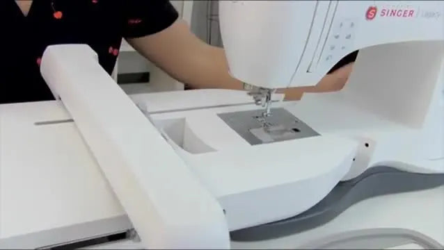 The embroidery unit locks onto the SINGER Legacy machine with a clear “snap,” signaling it’s fully seated and ready for calibration.