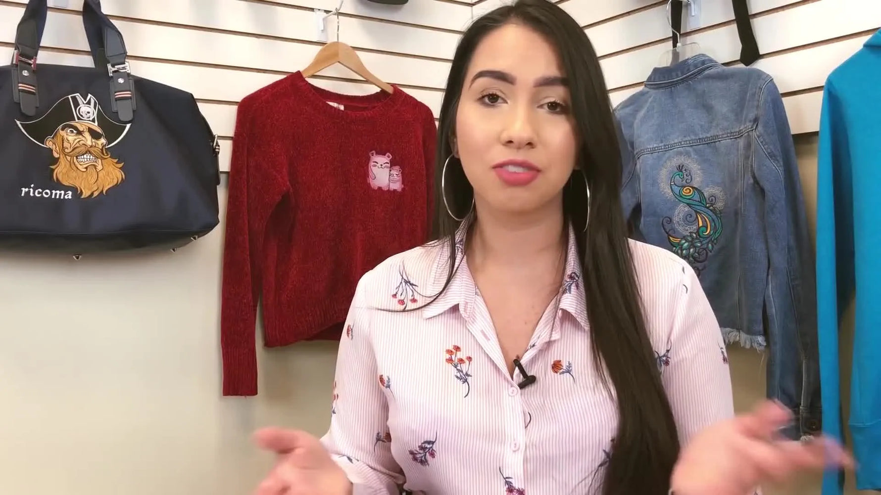 A woman in a floral shirt explains embroidery tips.