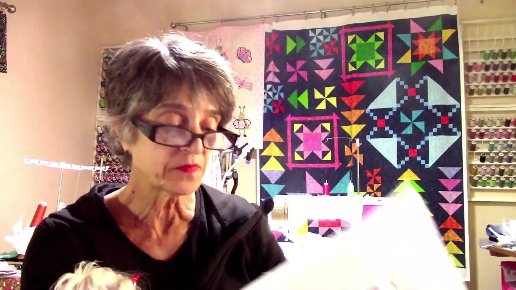 The finished Kimberbell “Let Me Call You Tweet Heart” embroidery block is held up to show the quilting, applique placement, and the 3D fringe flowers.