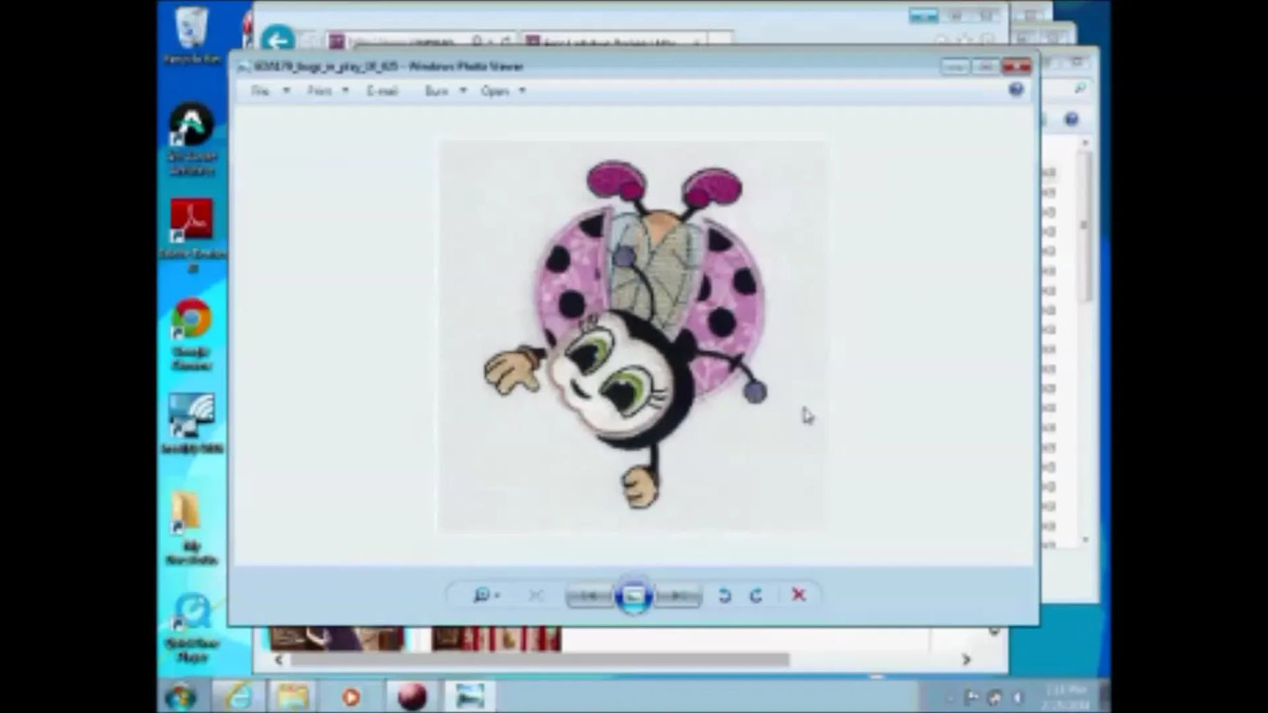 Screenshot of a computer screen displaying an embroidery design of a pink ladybug in Windows Photo Viewer.