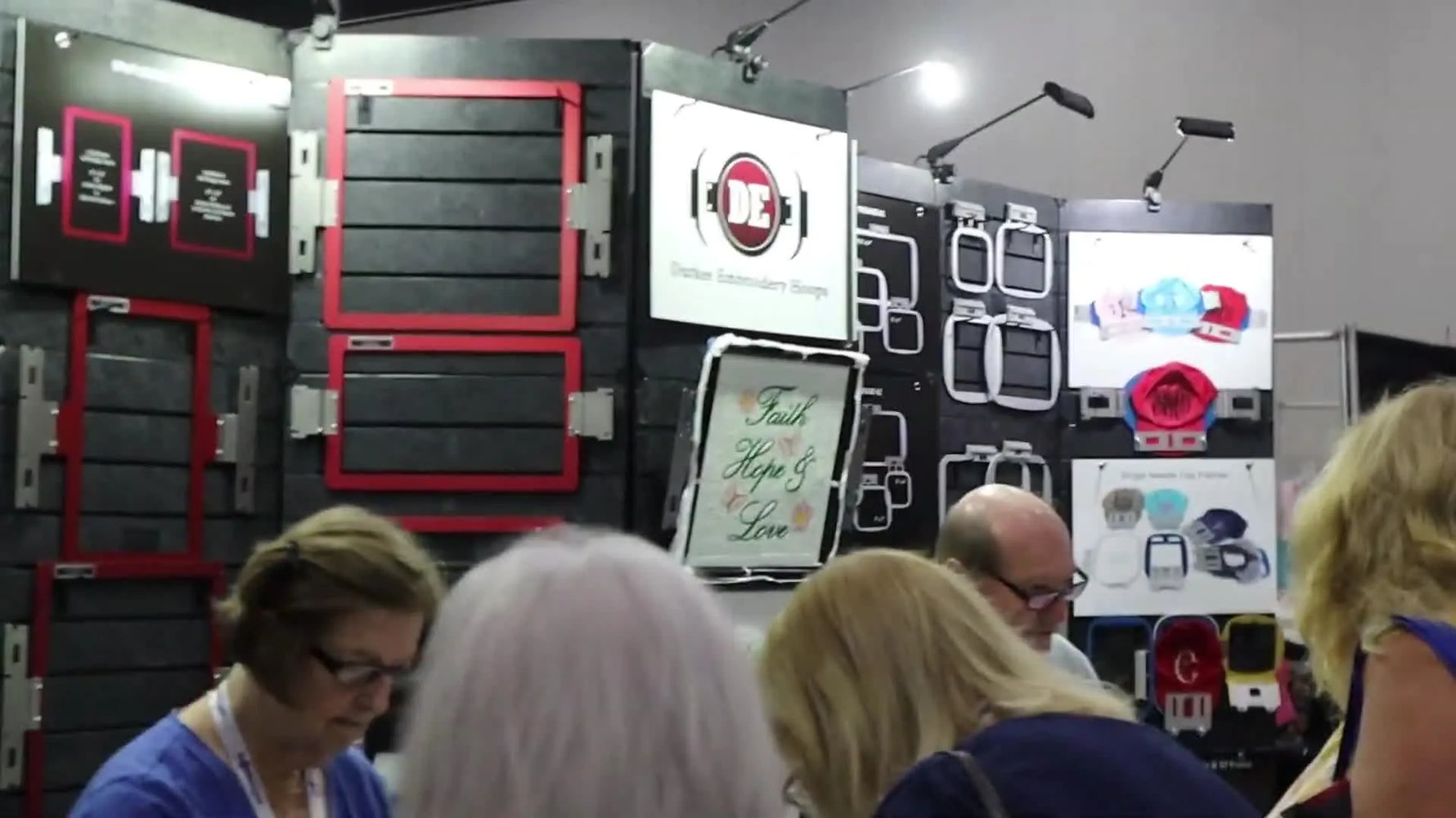 A wall display of Durkee embroidery hoops in multiple sizes, photographed on the trade show floor.