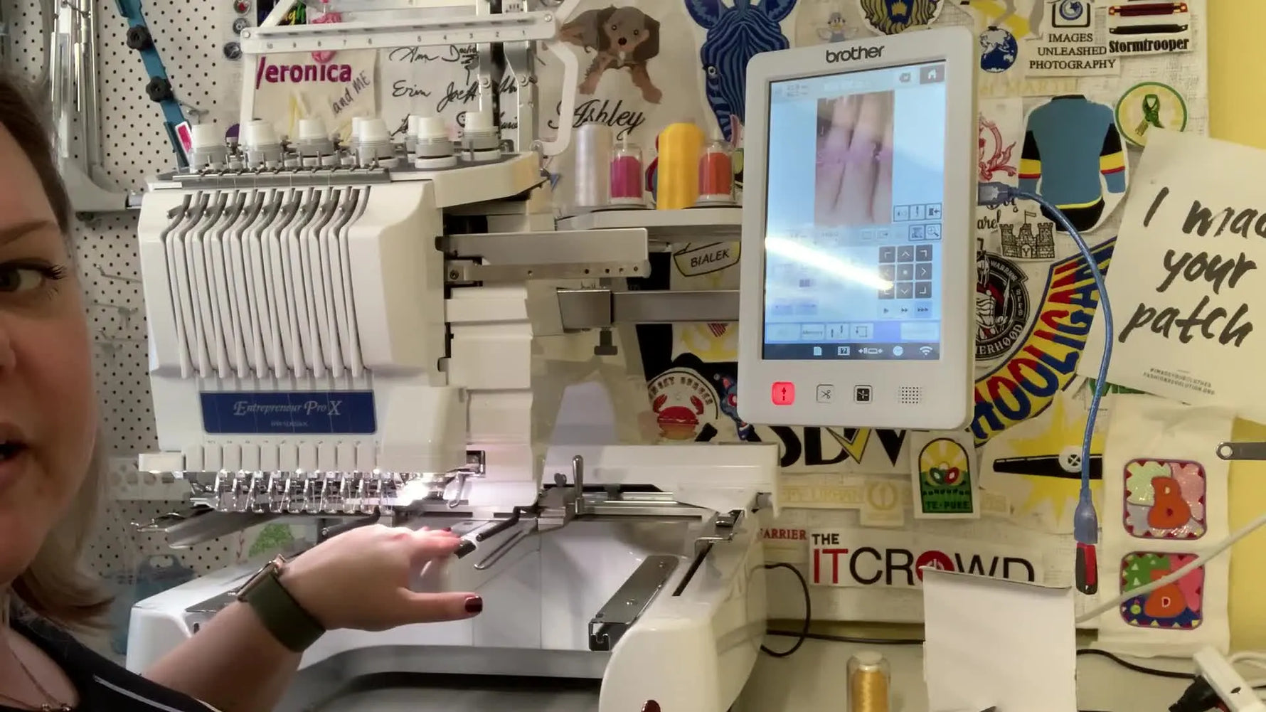 A close-up of the Brother PR1055X screen in Live View, showing fingers positioning a sleeve under the needle with crosshairs for precise alignment.