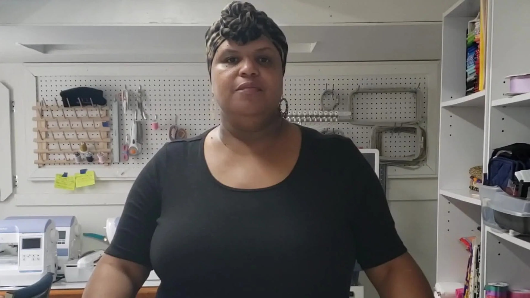 Woman in black shirt and leopard-print headwrap introduces the video, looking directly at the camera.