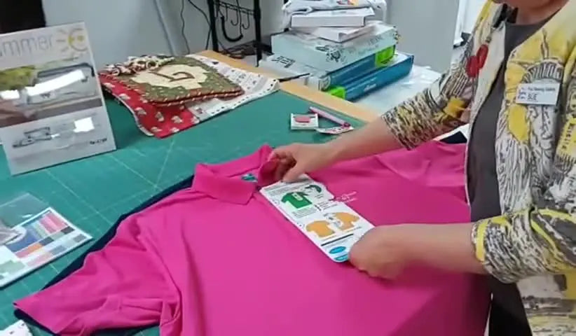 A close-up of the Embroidery Helper template perfectly aligned over a polo shirt button placket to lock in a straight, centered logo placement.