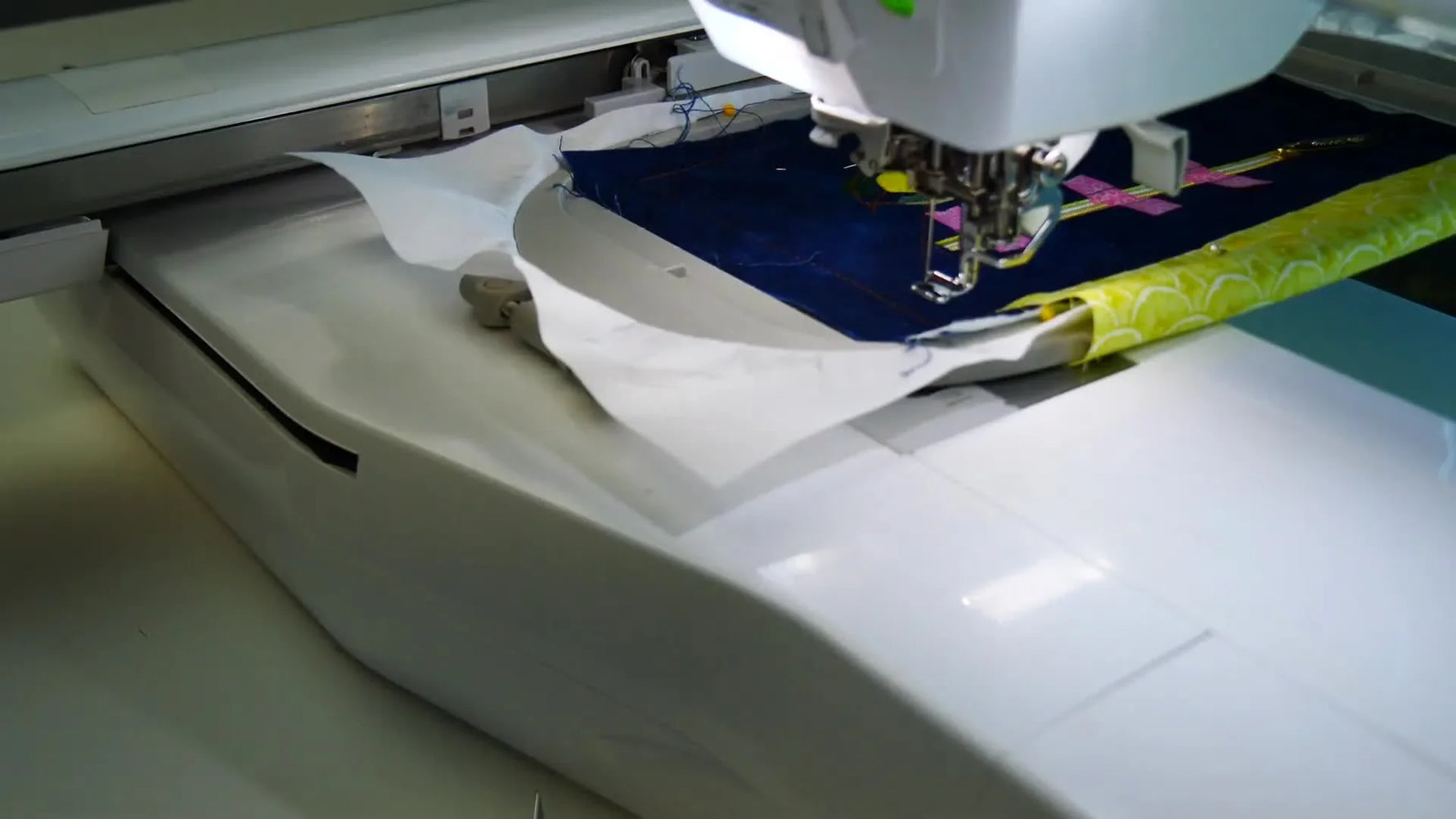 A finished in-the-hoop zipper installation sits neatly beside the lemon embroidery on the bag panel after the tape is removed.
