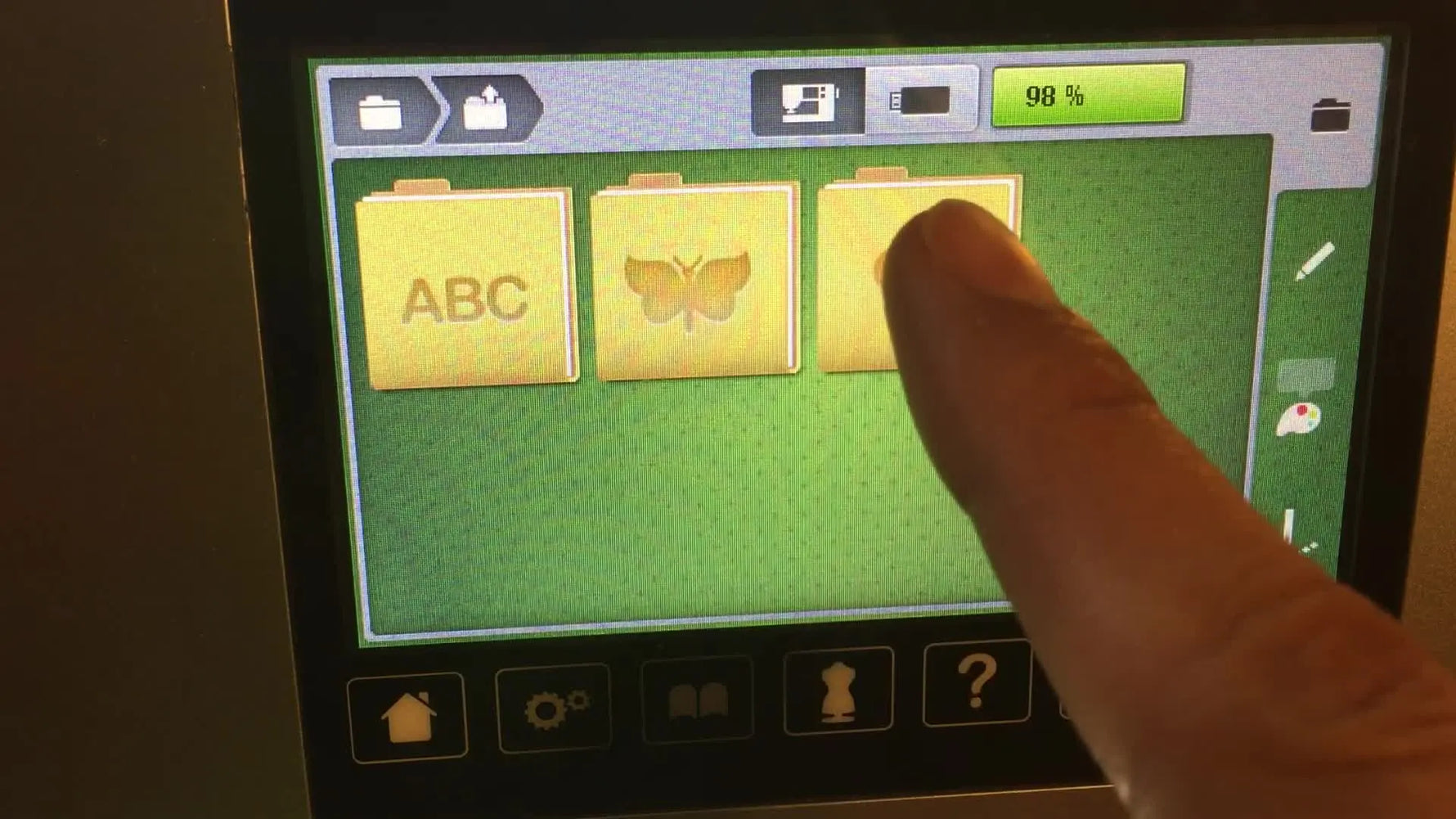 The Bernina 770 QE embroidery file list showing the buttonhole design automatically appearing as a selectable design slot after switching modes.