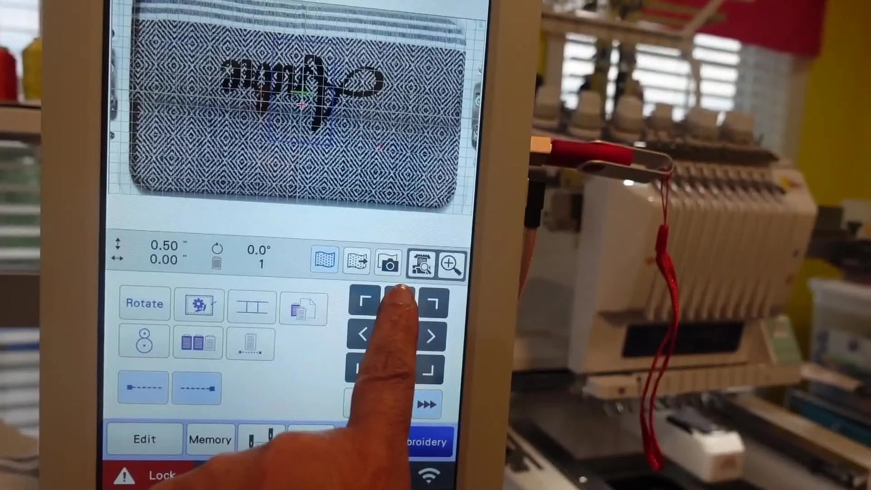 Close-up of the Brother PR1055X stitching the name “Andre” onto a Turkish towel inside an 8x13 magnetic hoop.