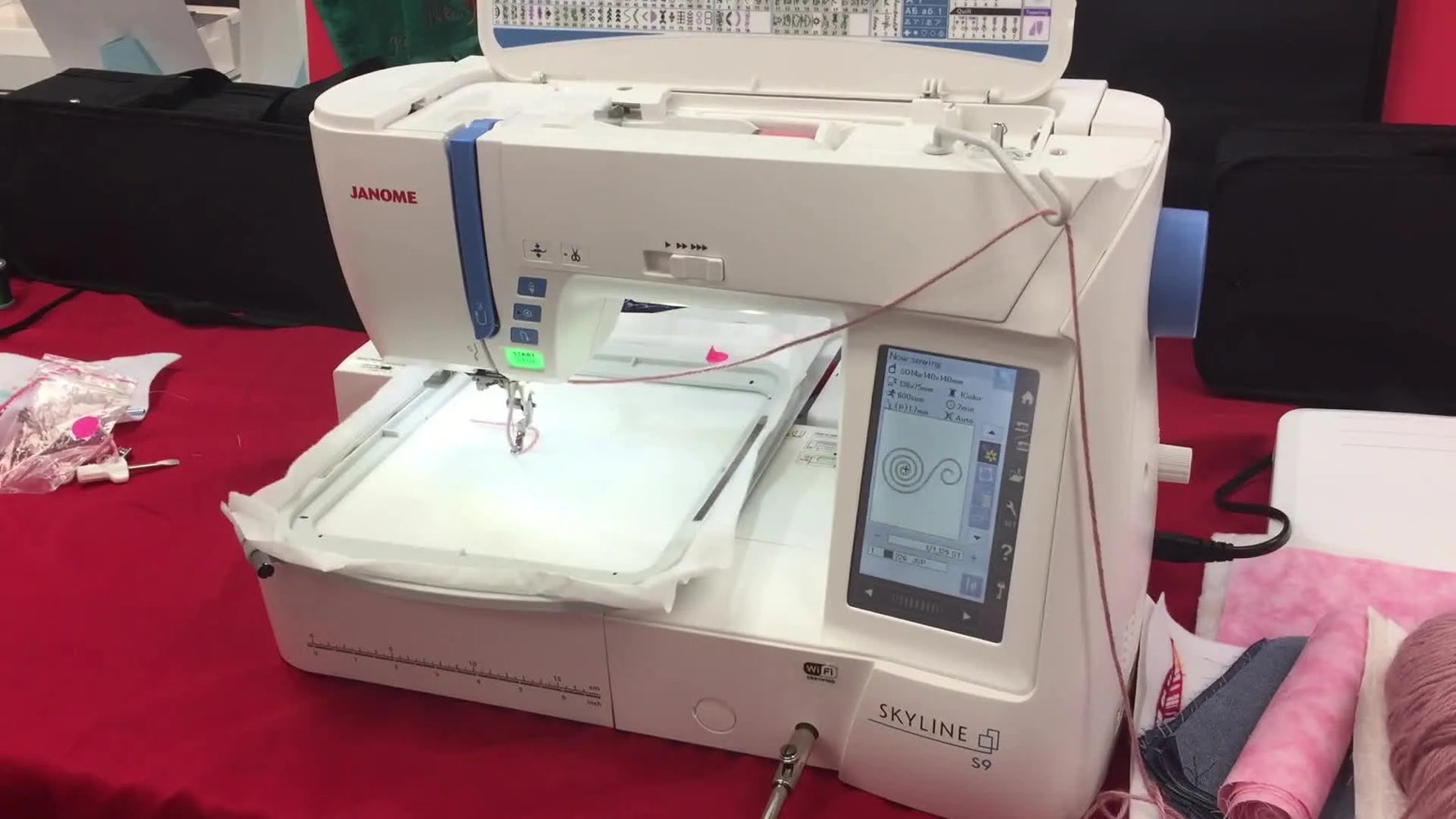 A close-up action shot of the Janome Skyline S9 couching foot stitching yarn into a raised spiral texture inside the hoop.